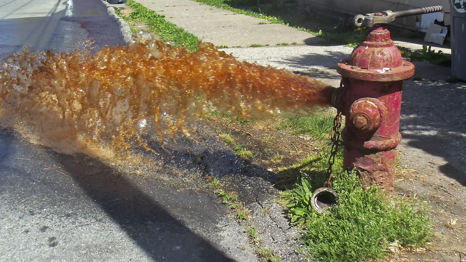 Rust-colored water pours from a fire hydrant during flushing. The picture is not from Germantown.