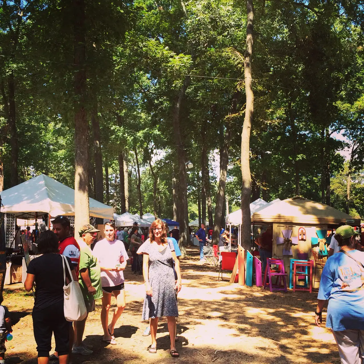 Festivalgoers walk between craft vendor tents under the trees at the Germantown Festival on Poplar Pike.