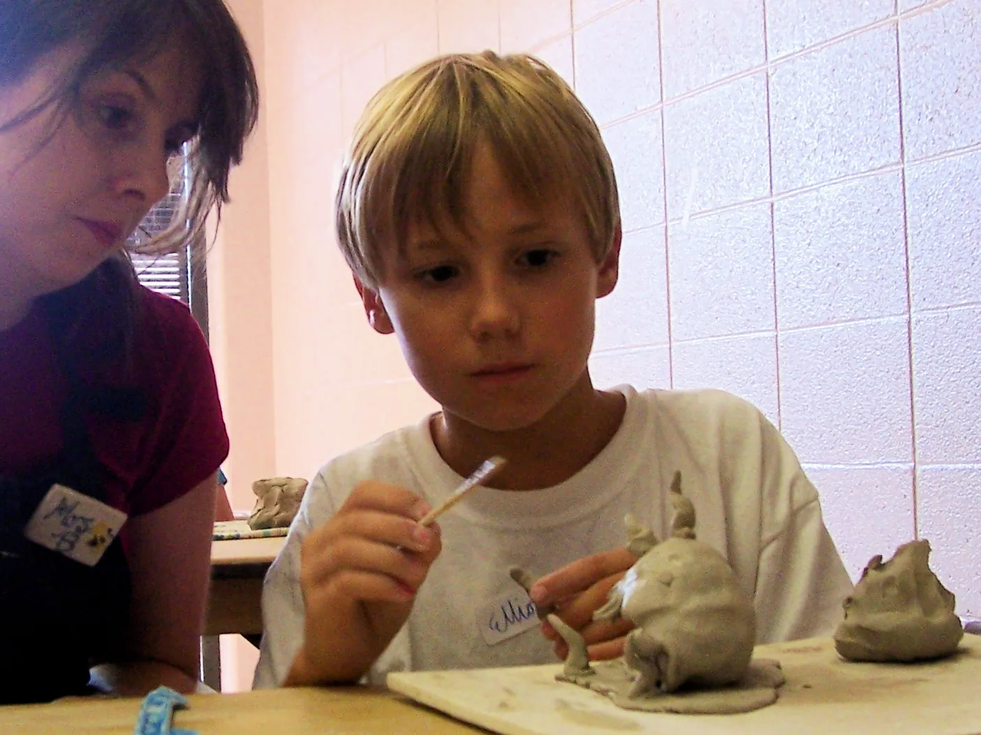 A boy shapes a clay figure during a children's ceramics class in Germantown.