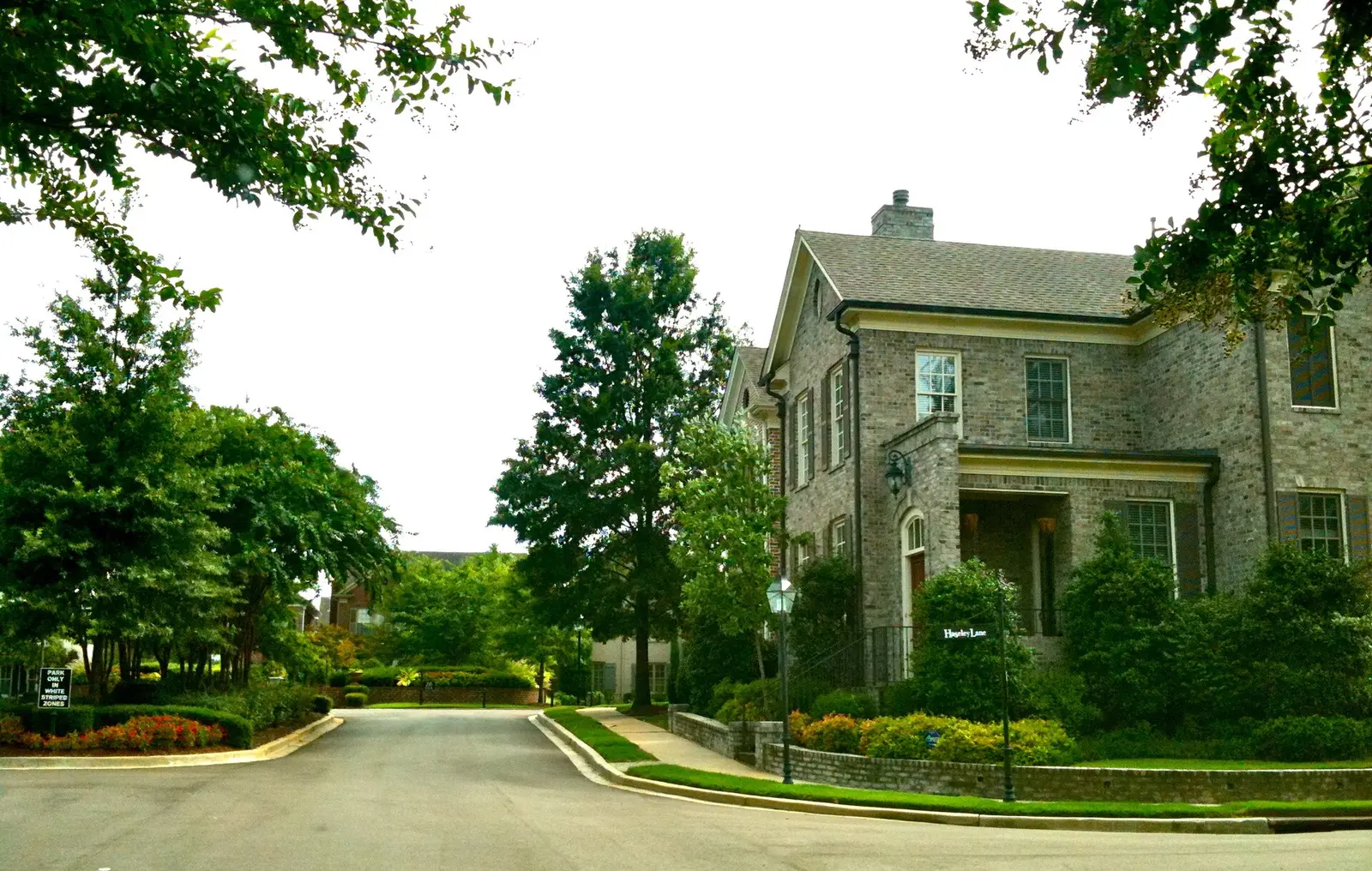 A brick house at the corner of a landscaped street in the Poplar Estates neighborhood of Germantown.
