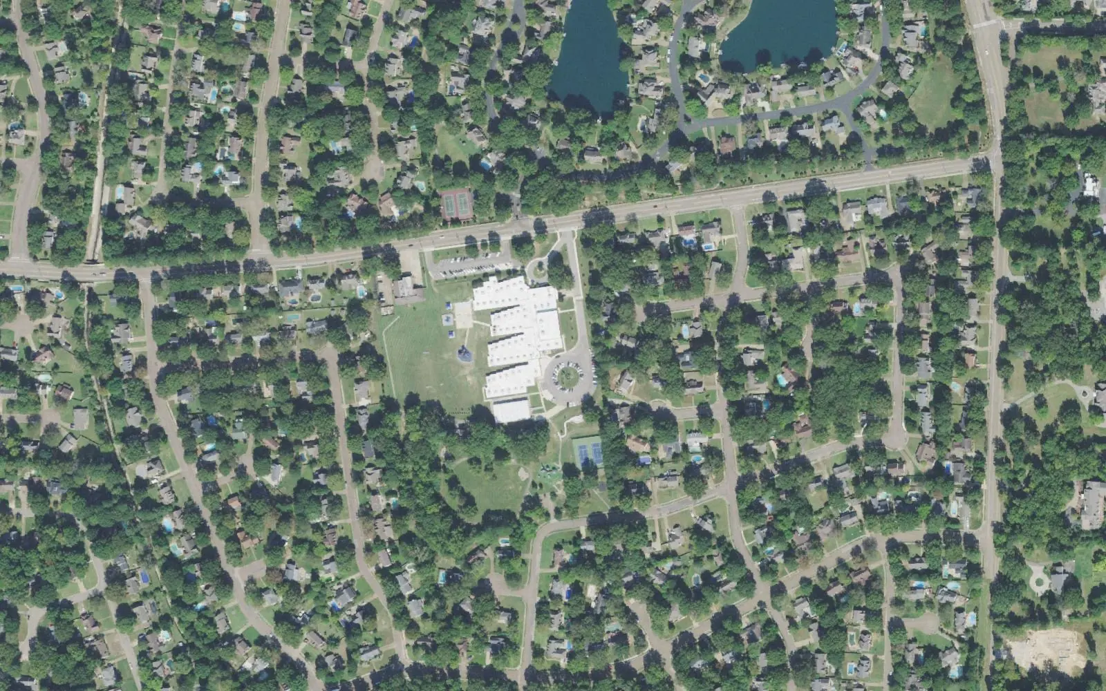 Dogwood Elementary School on Dogwood Road in east Germantown, seen from the air among houses on wooded streets, with two ponds at the top